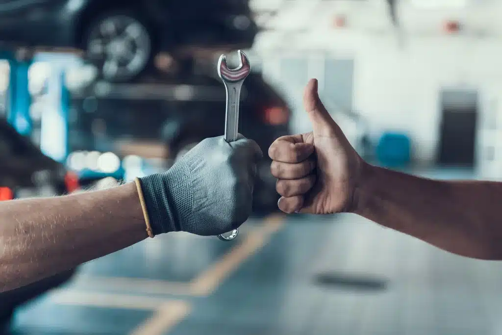 Vehicle servicing service promise man with spanner and thumbs up car battery care